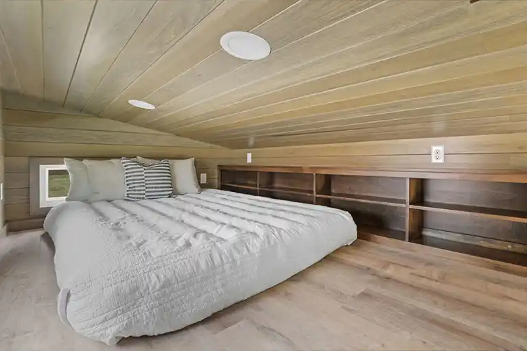 Large loft space with custom storage cubbies for a cozy sleeping area.