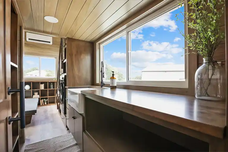 Efficient galley kitchen with brown maple countertops and custom cabinetry.