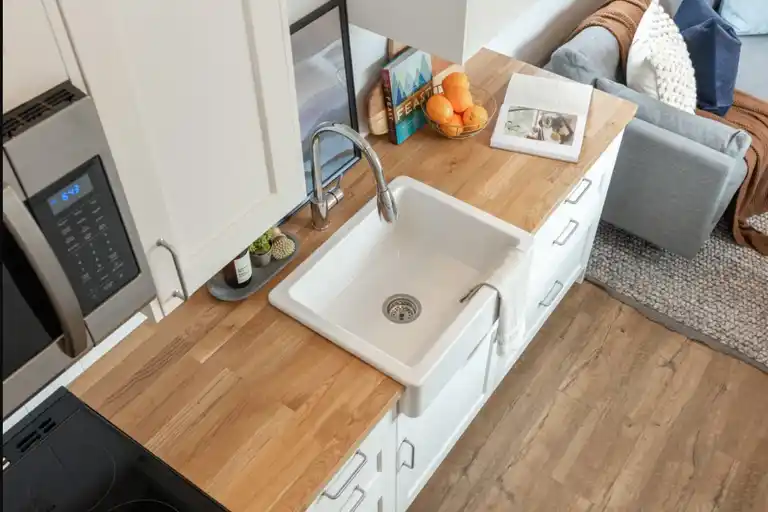 The galley kitchen features butcher block countertops and a propane cooktop.