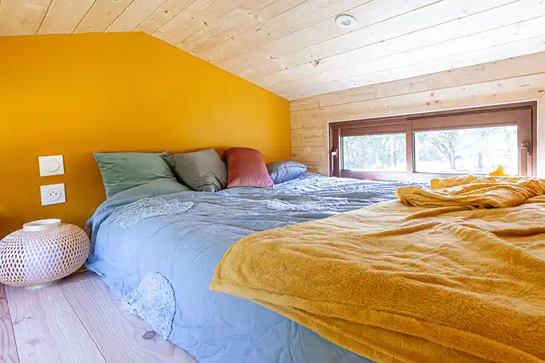 Main mezzanine with a double bed and cozy wood finishes.