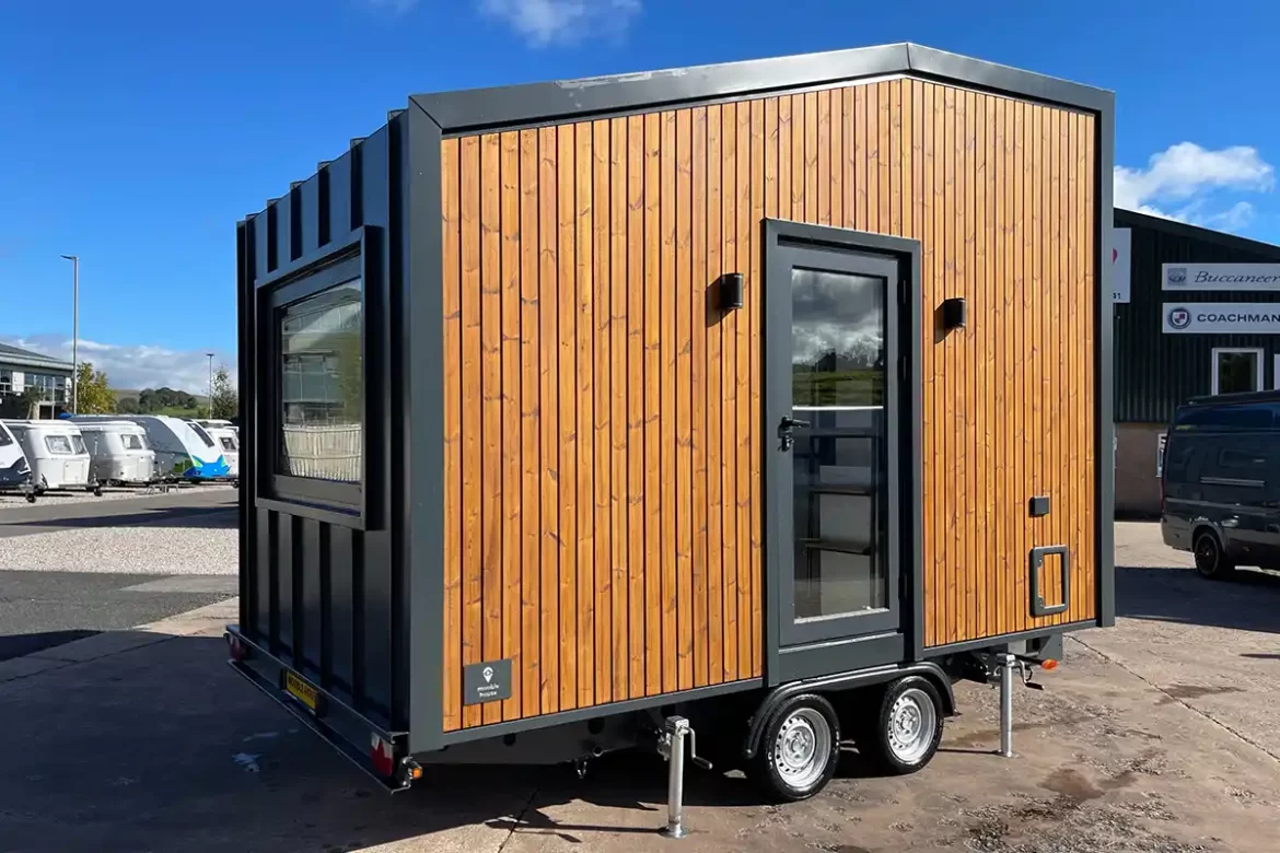 The Mo.5 450H tiny house by Mooble House UK with a unique wood and metal exterior.