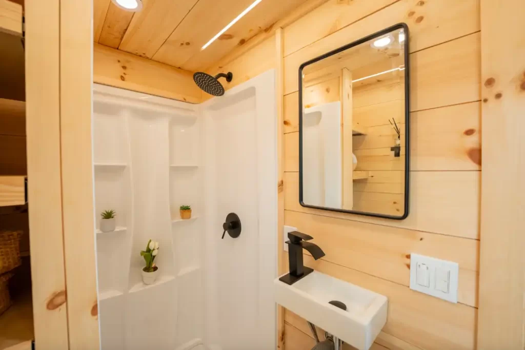 Full bathroom with a 48″ shower, flush toilet, and compact sink.