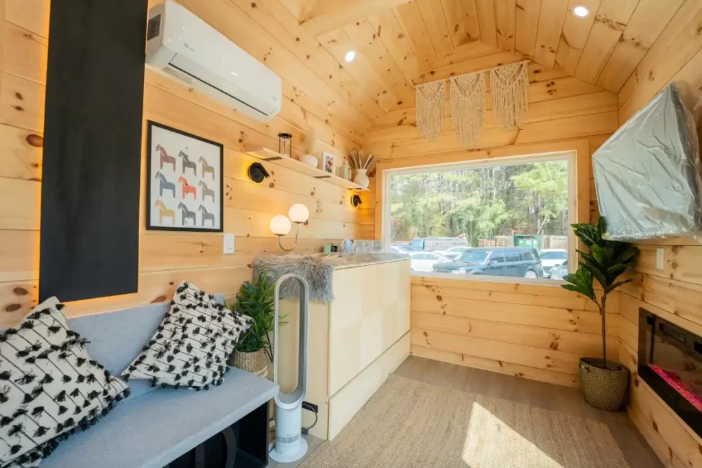 Main-floor queen bed positioned beside a large picture window.