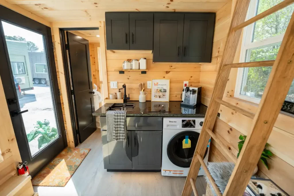 Simple kitchen with granite countertops, induction cooktop, and pine cabinetry.