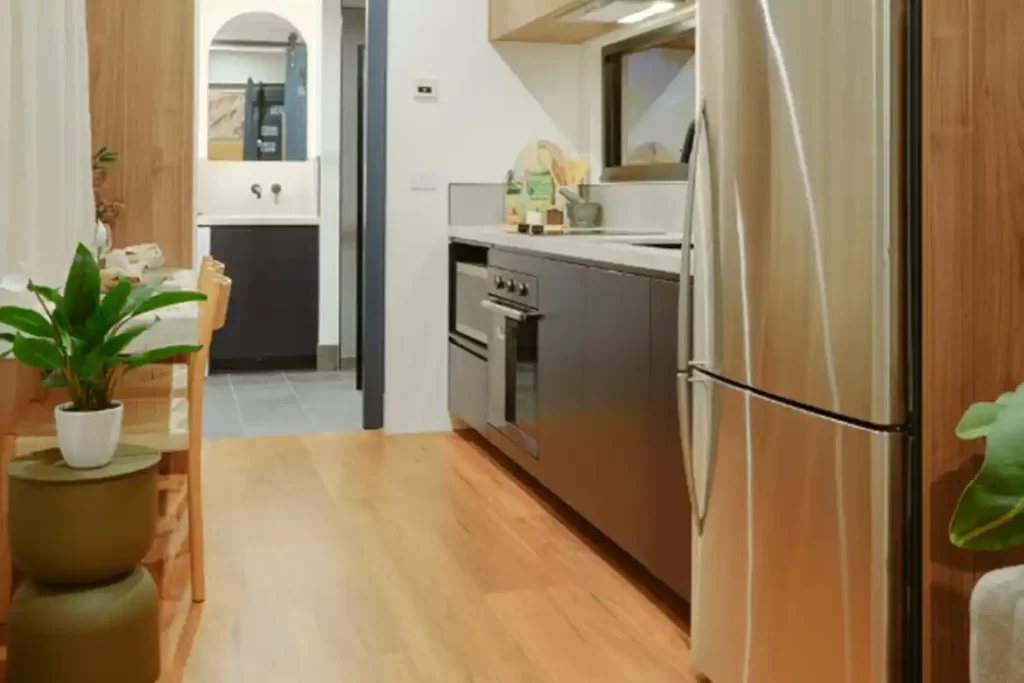 Kitchen area with ceramic cooktop, oven, and round double glazed window.